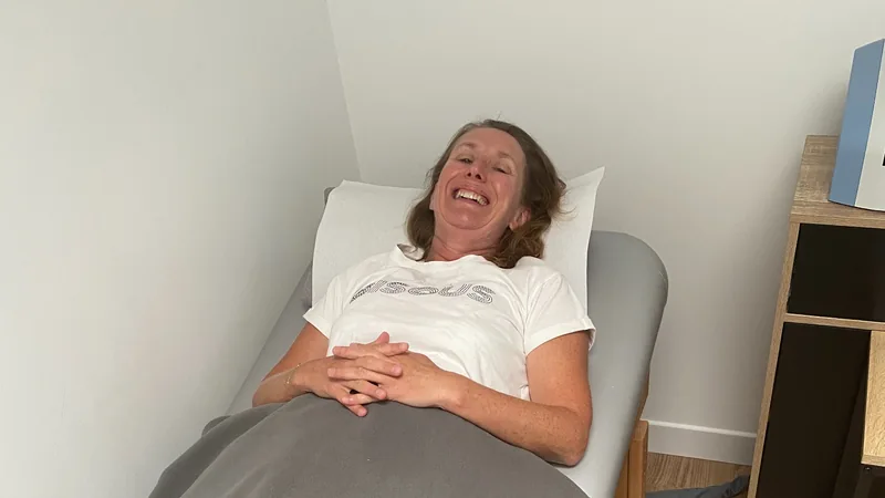 Une cliente installée sur une table de soin sous une couverture dans l'espace bien-être du centre Cryotera.