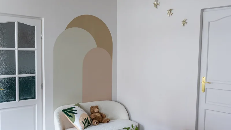 Espace d'accueil du cabinet d'avocate à Marchiennes avec canapé blanc, fauteuils en rotin et décoration douce adaptée aux familles.
 Copier l'alt